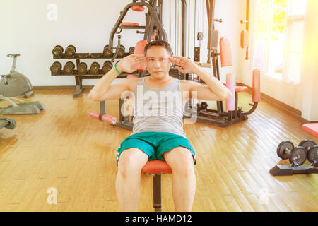 Asia man middle aged sit up in the gym for strength, weight loss. Stock Photo