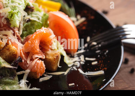 Concept: restaurant menus, healthy eating, homemade, gourmands, gluttony. Caesar salad with salmon and cherry tomatoes on a weathered wooden backgroun Stock Photo