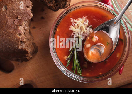 Concept: restaurant menus, healthy eating, homemade, gourmands, gluttony. Gazpacho in a glass bowl on a messy wooden background. Top-down view. Stock Photo