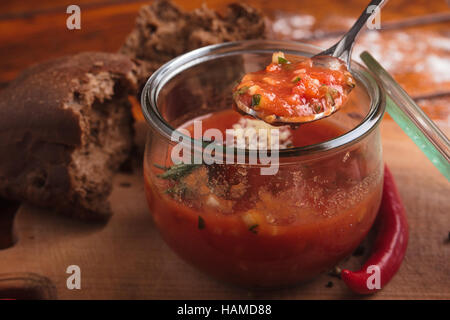 Concept: restaurant menus, healthy eating, homemade, gourmands, gluttony. Gazpacho in a glass bowl on a messy wooden background. Stock Photo