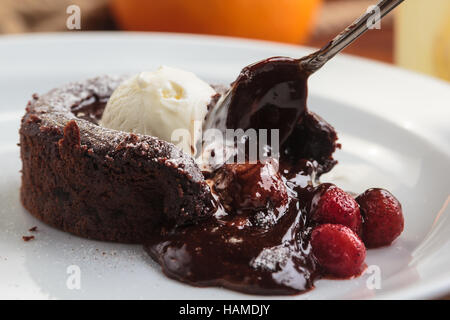 Concept: restaurant menus, healthy eating, homemade, gourmands, gluttony. White plate with chocolate fondant with strawberry and ice cream on a messy  Stock Photo