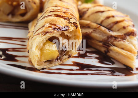Concept: restaurant menus, healthy eating, homemade, gourmands, gluttony. White plate of strudel with apple on vintage wooden table. Stock Photo