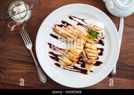 Concept: restaurant menus, healthy eating, homemade, gourmands, gluttony. White plate of strudel with apple on vintage wooden table. Top-down view Stock Photo