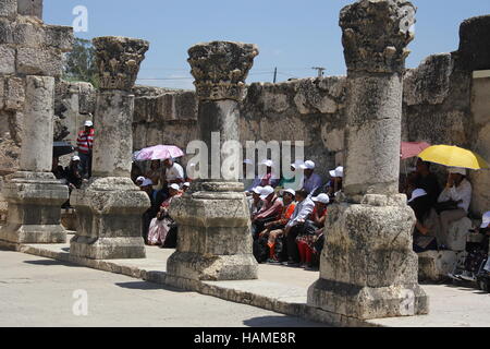 A tour group sits in the ruins of the synagogue where Jesus taught. Capernaum, Israel, in 2016 Stock Photo