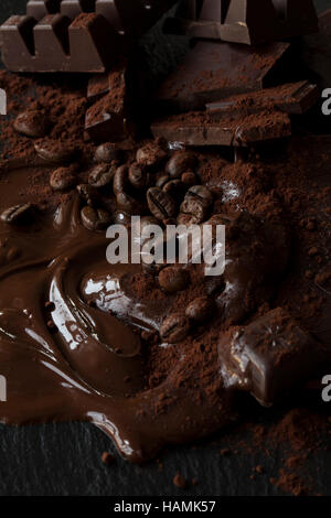 Melted chocolate with coffee beans, cocoa powder and chocolate pieces. Stock Photo