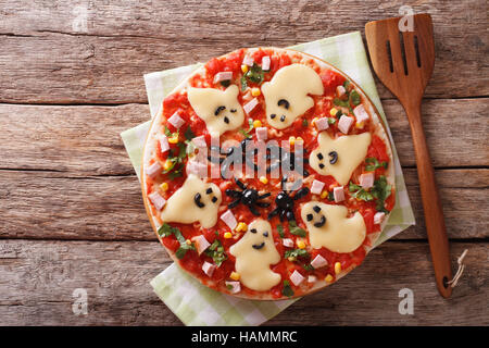 Halloween Food: Pizza with ghosts and spiders close-up on the table. horizontal view from above Stock Photo