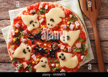 Pizza Halloween with ghosts cheese and olives spiders close-up on the table. Horizontal view from above Stock Photo