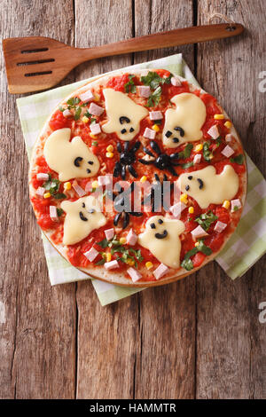 Halloween Food: Pizza with ghosts and spiders close-up on the table. Vertical view from above Stock Photo