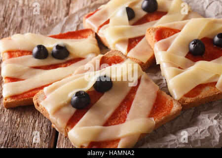 Halloween sandwiches with cheese, ketchup and olives close-up on the table. horizontal Stock Photo