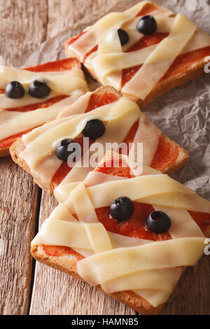 Halloween food: sandwiches mummy close up on the table. vertical Stock Photo