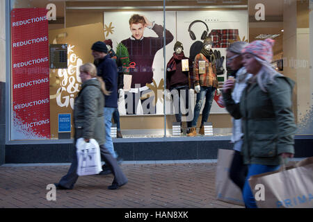 People passing Primark Sale reductions and Christmas window display, shop, shoppers, shopping on Black Friday week, Blackpool, Lancashire, UK Stock Photo