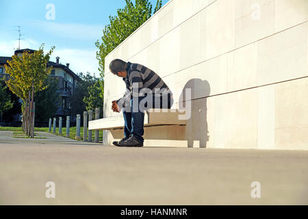 man sitting on  bench reflects and enjoys  beautiful sunny d Stock Photo