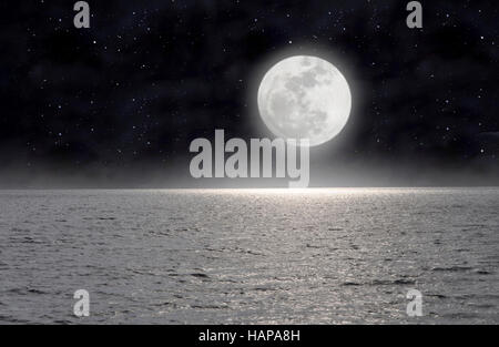 In the starry night the moon lights up the sea Stock Photo