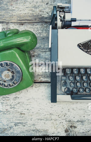 Old typewriter and old green phone on the table Stock Photo