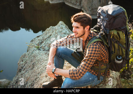 Top view of adventure man sitting on rock looking away. Stock Photo