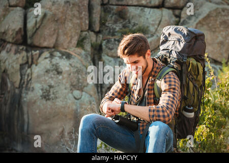 Close up tourist man sitting on rock near the canyon Stock Photo