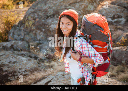 Tourist woman with backpack near the canyon. looking at camera. stands sideways. top view Stock Photo