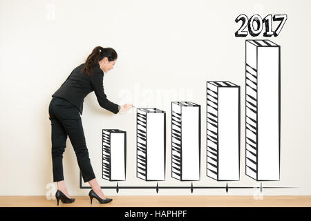business woman drawing over target achievement graph on white wall background. Concept of scientific approach to business. beautiful mixed race asian  Stock Photo