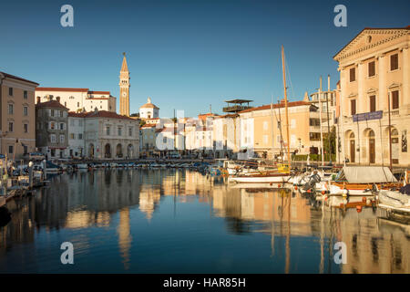 Evening sunlight on Marina, spire of St. George's Parish Church and town center (Tartinijev trg), Piran, Primorska, Slovenia Stock Photo