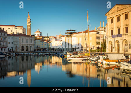 Evening sunlight on Marina, spire of St. George's Parish Church and town center (Tartinijev trg), Piran, Primorska, Slovenia Stock Photo