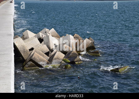 Breakwater blocks in the port. Breakwater of the rectangular stone figures. Stock Photo