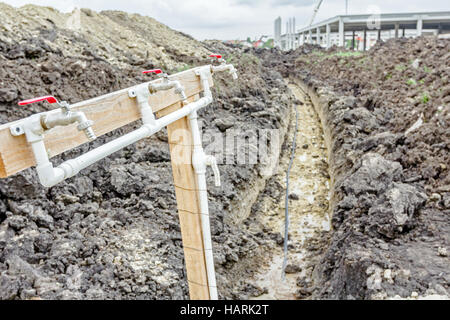 Several faucets with fresh water are placed temporarily at construction site for washing worker's hands. Stock Photo