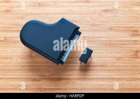 Black toy grand piano on a wooden floor with stool standing near it. Top view. Music concept. Stock Photo