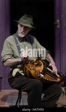 A street entertainer  playing the hurdy gurdy, a traditional stringed instrument at sweeps festival in rochester england Stock Photo