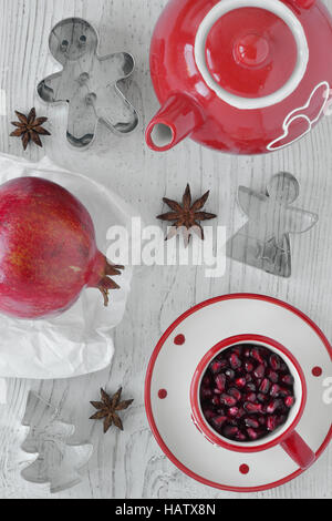 Composition with pomegranate, star anise, tea set and cookie cutters Stock Photo