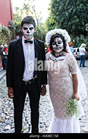 A couple dressed as the dapper skeleton and La Calavera Catrina costumes for Day of the Dead festival in San Miguel de Allende, Guanajuato, Mexico. The week-long celebration is a time when Mexicans welcome the dead back to earth for a visit and celebrate life. Stock Photo