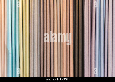 Colorful curtain samples hanging from hangers on a rail in a display in a retail store Stock Photo