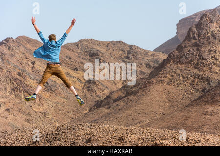 Happy young man is jumping in the desert Stock Photo