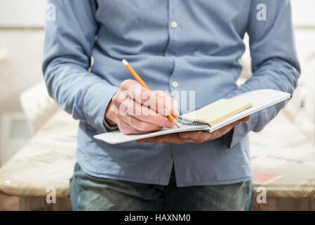 man who writes notes on notebook in office Stock Photo