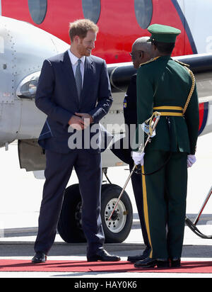 Prince Harry speaks with Governor General Elliott Belgrave (centre) as he prepares to leave Grantley Adams International Airport in Barbados as he heads to Guyana, as part of his tour of the Caribbean. Stock Photo