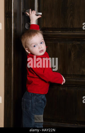 little boy tries to open door Stock Photo