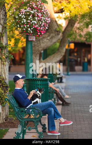 A local enjoys a warm October evening in the Historic Plaza in downtown Santa Fe New Mexico USA. Stock Photo