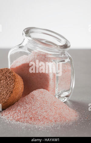 pink Himalayan salt in glass jar on gray and white background Stock Photo