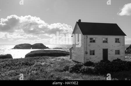 Sun shines on bird island behind an abandoned derelict house in Maberly, Newfoundland. Stock Photo