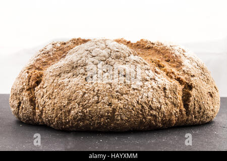 freshly baked brown irish soda bread with flour on slate Stock Photo