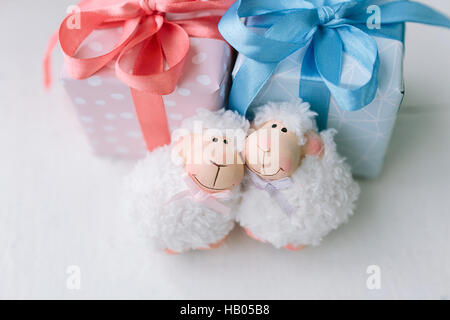 pink and blue boxes with gifts. two small toys - lambs. Stock Photo
