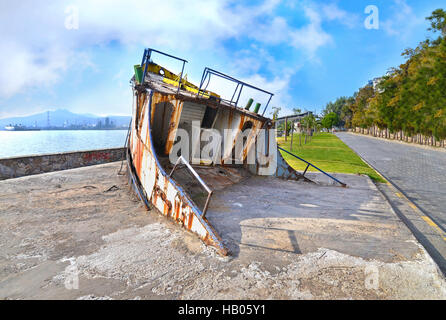 wreck boat on the road at Eleusis Greece Stock Photo