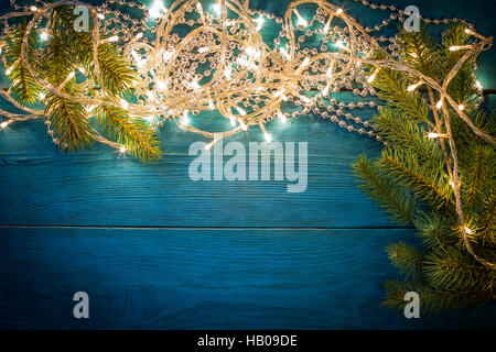 Christmas tree branch with silver beads on wooden table. Top view with copy space Stock Photo