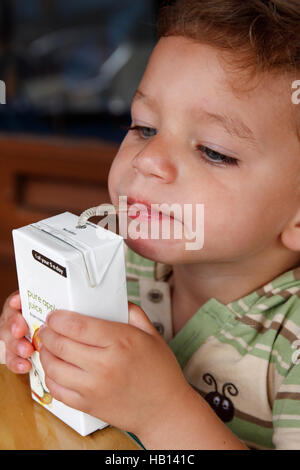 little boy drinking pure apple juice from carton Stock Photo