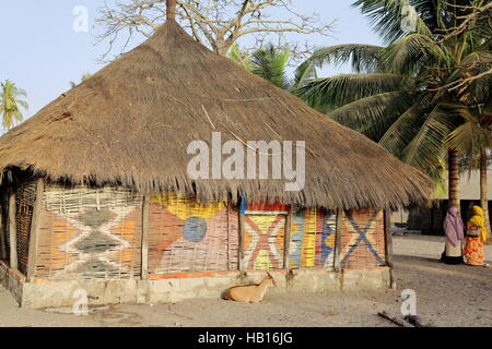 Diola people.s thatch-roofed townrural house with palm-matted walls decorated of traditional African motifs in the village Carabane island Stock Photo