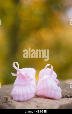 white Baby booties on a green natural background Stock Photo