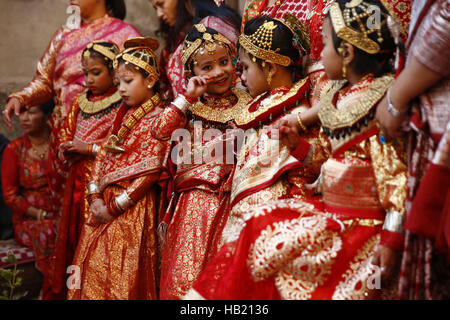 Bhaktapur, Nepal. 4th Dec, 2016. Nepalese Newar girls react before prayers during Bel Bibaha or Ehee rituals in Bhaktapur, Nepal on Sunday, December 4, 2016. Pre adolescent girls from Newar community get married thrice, the first to the Bel or holy fruit, second is the marriage with the Sun and the third a real husband. Performing these rituals to ward evil spirits, but mainly to protect her from widowhood holds the ritual ceremony. Credit:  Skanda Gautam/ZUMA Wire/Alamy Live News Stock Photo