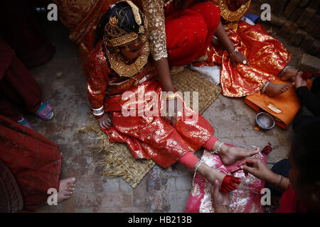 Bhaktapur, Nepal. 4th Dec, 2016. A Nepalese Newar girl getting her feet smeared with color during Bel Bibaha or Ehee rituals in Bhaktapur, Nepal on Sunday, December 4, 2016. Pre adolescent girls from Newar community get married thrice, the first to the Bel or holy fruit, second is the marriage with the Sun and the third a real husband. Performing these rituals to ward evil spirits, but mainly to protect her from widowhood holds the ritual ceremony. Credit:  Skanda Gautam/ZUMA Wire/Alamy Live News Stock Photo