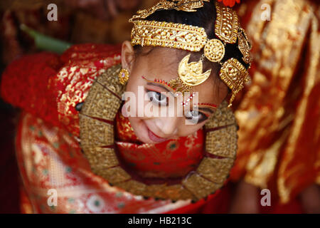 Bhaktapur, Nepal. 4th Dec, 2016. A Nepalese Newar girl reacts during Bel Bibaha or Ehee rituals in Bhaktapur, Nepal on Sunday, December 4, 2016. Pre adolescent girls from Newar community get married thrice, the first to the Bel or holy fruit, second is the marriage with the Sun and the third a real husband. Performing these rituals to ward evil spirits, but mainly to protect her from widowhood holds the ritual ceremony. Credit:  Skanda Gautam/ZUMA Wire/Alamy Live News Stock Photo