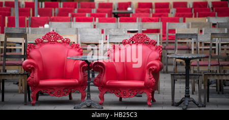 Two red plastic armchairs stand in front of the Café Tambos at Odeons square in Munich, Germayn, 1 December 2016. Photo: Peter Kneffel/dpa Stock Photo