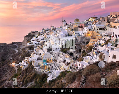 Oia Village in Cycladic Architecture style in Santorini, Greece during a pink sunset.